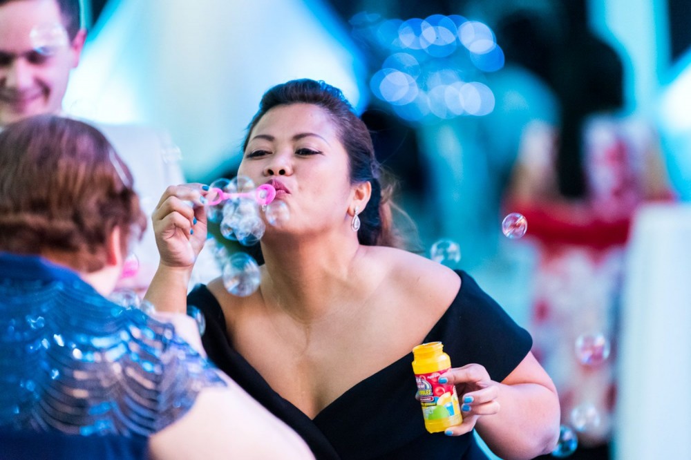 Deaf woman from Filipino background is having fun, blowing bubbles in formalwear